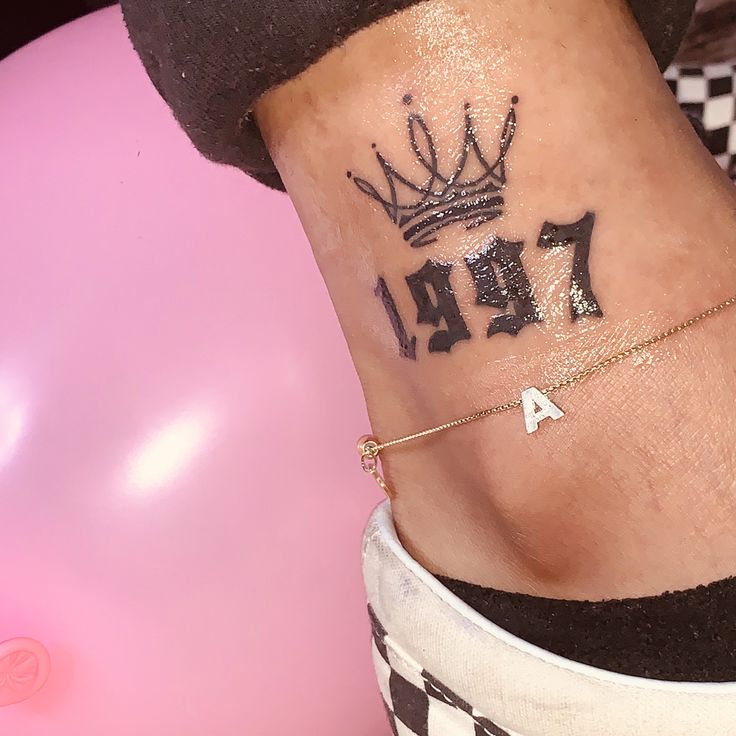 a woman with a tattoo on her stomach that says fala and is wearing a crown