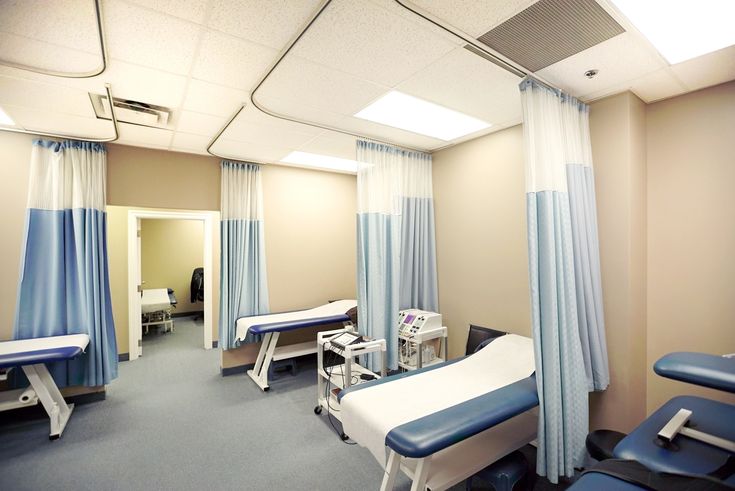 a hospital room with blue and white drapes