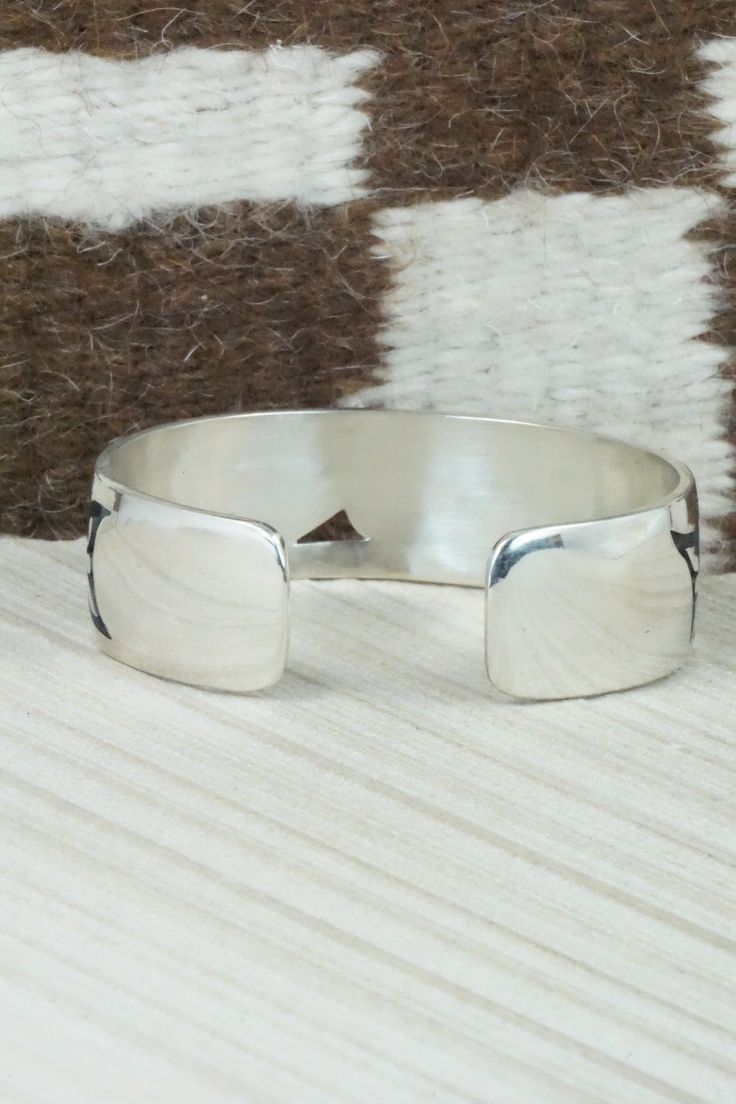 This sterling silver bracelet was made by Hopi silversmith Timothy Mowa. The inside is signed and stamped sterling.Size: 5 3/4" (will fit up to a 6 1/4" wrist)Gap: 3/4"Width: 3/4"Free shipping on all orders! We ship with USPS and always include tracking. All orders ship within a day of payment.Returns are accepted up to 30 days after you receive your order. Just send us a message. Our shop offers cash back or store credit. The item must be returned in new condition. Stamped Sterling Silver Cuff Bracelet, Sterling Silver Stamped Cuff Bangle, Artisan Adjustable Sterling Silver Bracelet, Adjustable Artisan Sterling Silver Bracelet, Adjustable Sterling Silver Bangle, Adjustable Sterling Silver Chain Bracelet, Adjustable Open Band Bracelet With Polished Finish, Adjustable Polished Open Band Bracelet, Adjustable Round Cuff Bracelet With Sterling Silver Clasp