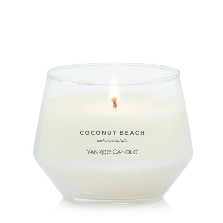 yankee candle in a clear glass container on a white background with the words coconut beach