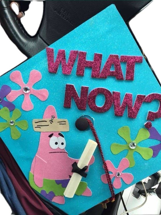 a blue graduation cap with the words what now? on it and a cartoon character