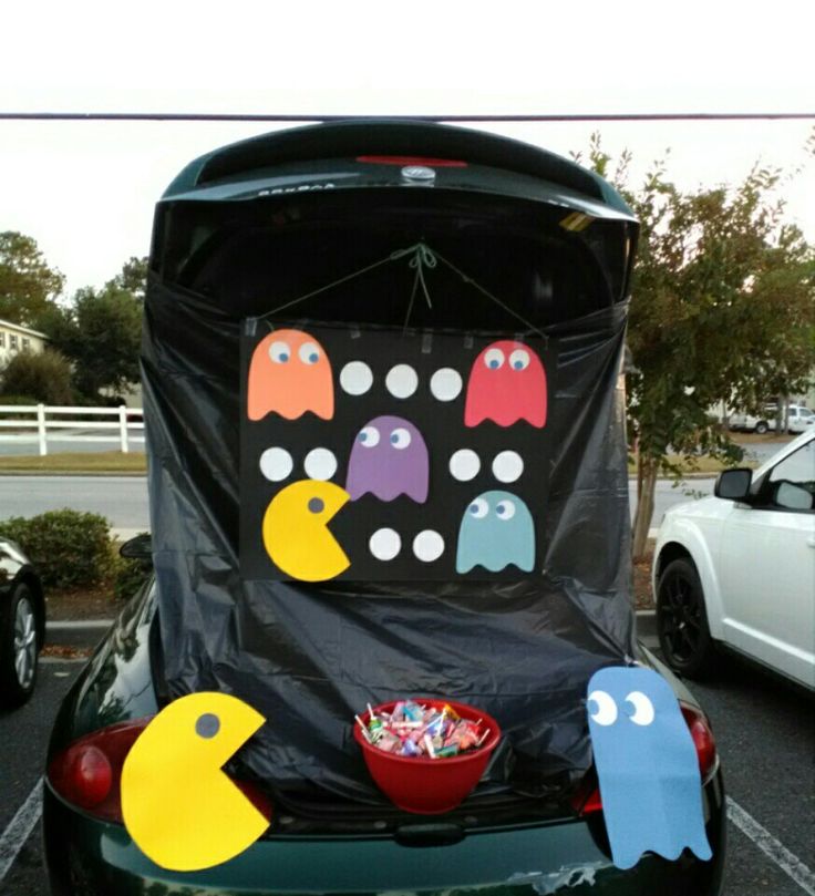 the back end of a car decorated with halloween decorations and paper cutouts, in a parking lot