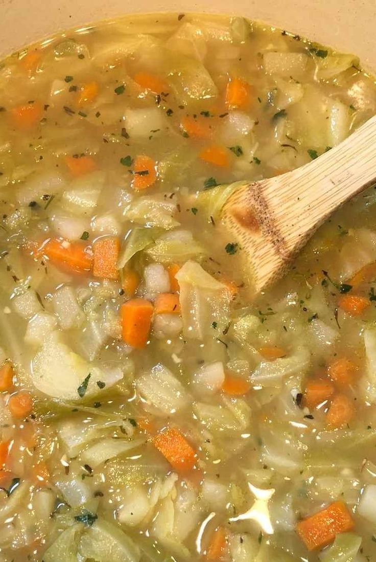 a wooden spoon in a pot filled with soup