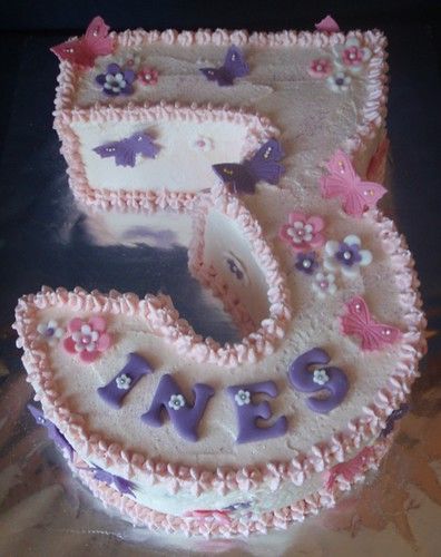 a birthday cake with the number five decorated in pink and purple icing, sitting on top of a table