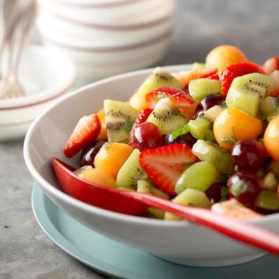 a white bowl filled with fruit salad on top of a table