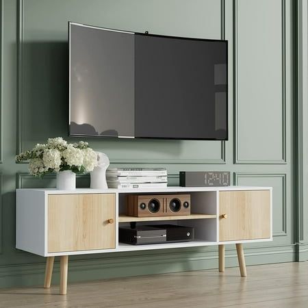 an entertainment center with a flat screen tv mounted on it's wall and wooden legs