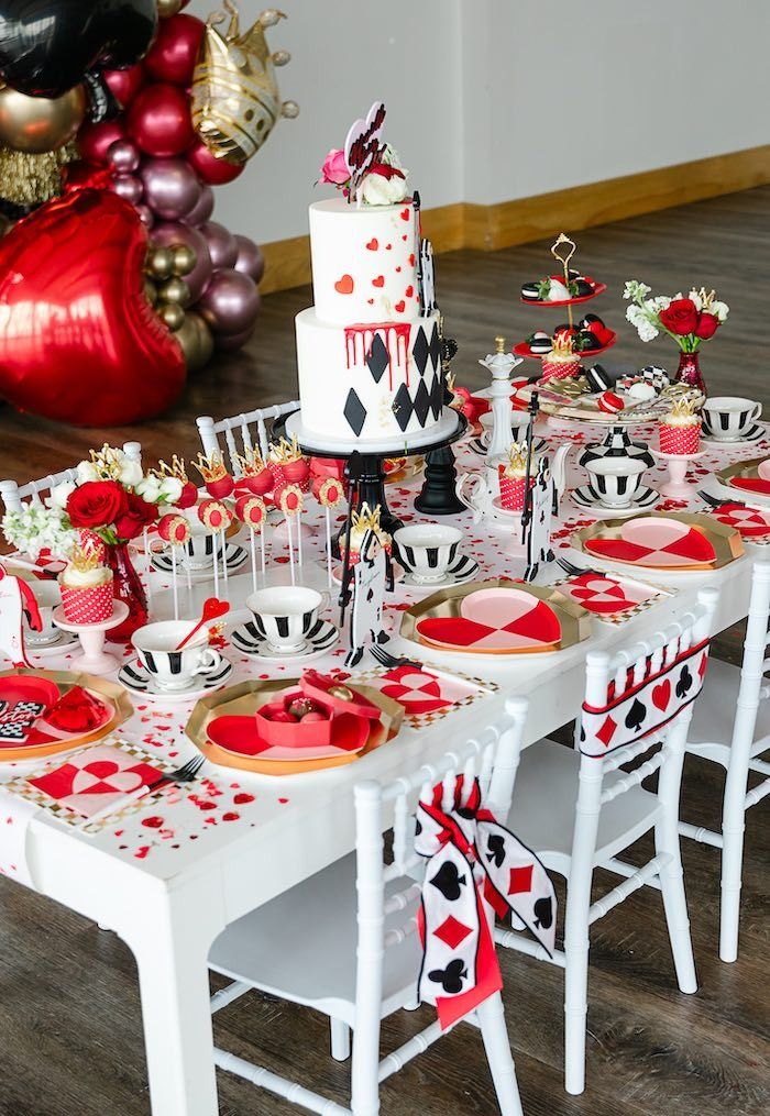 a table set up for a party with red, white and black decorations