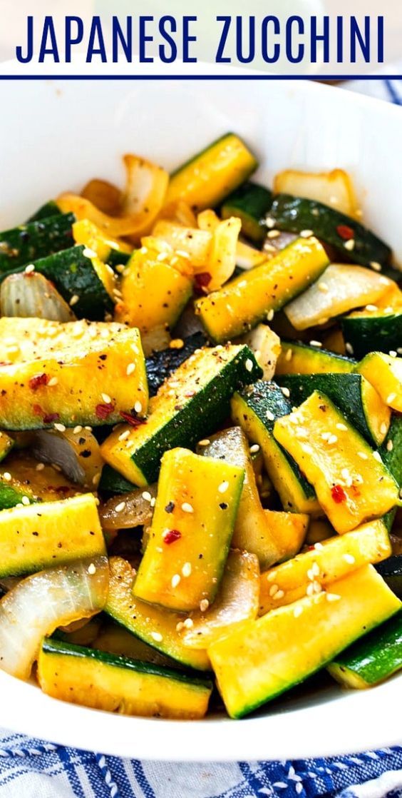 a white bowl filled with zucchini and other vegetables