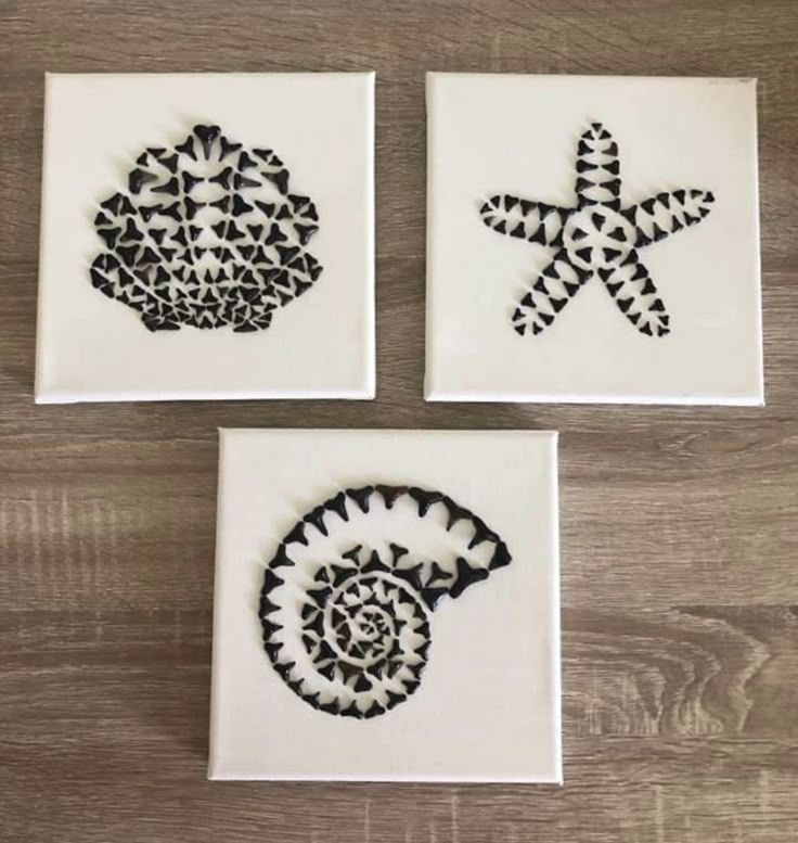 three coasters with black and white designs on them sitting on a wooden table next to each other