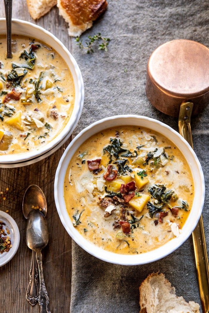 two bowls of soup with bread on the side