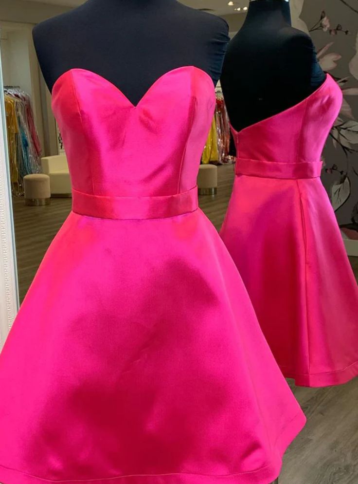 Crowned with an elegant waistband that accentuates its timeless cut, this hot pink homecoming dress is both bold and beautiful. Crafted from lustrous satin, the dress reflects light and commands presence, ensuring the wearer stands out with confidence and style. The classic silhouette, with its fitted bodice and flared skirt, invokes a sense of 1950s glamour, updated for the contemporary young woman. Its vibrant shade is not just pink; it's an exclamation of joy and celebration, perfect for the spirited atmosphere of homecoming. This dress is designed for making memories, laughing with friends, and dancing the night away under the glittering lights of a once-in-a-lifetime evening. Prom Dress Hot Pink, Hot Pink Prom Dresses, Hot Pink Homecoming, Pink Prom Dresses Short, Hot Pink Homecoming Dress, Cocktail Pink, Hot Pink Prom Dress, Strapless Homecoming Dresses, Formal Dresses Graduation