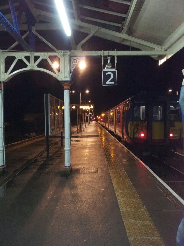 a train is pulling into the station at night