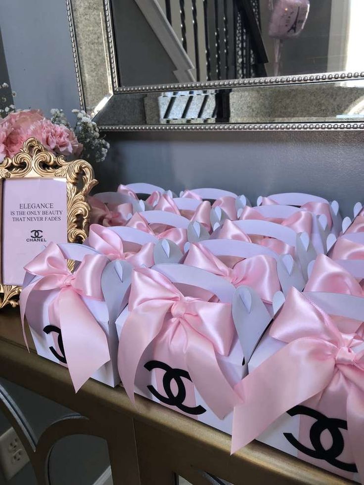 pink and white bows are on display in front of a mirror with a chanel sign