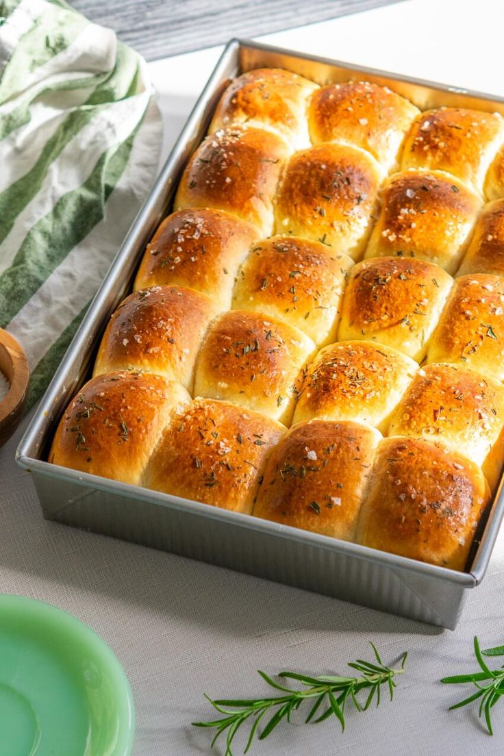 a pan filled with bread sitting on top of a table next to a green plate