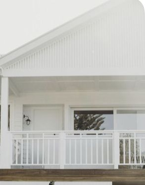 a white house with a porch and railing