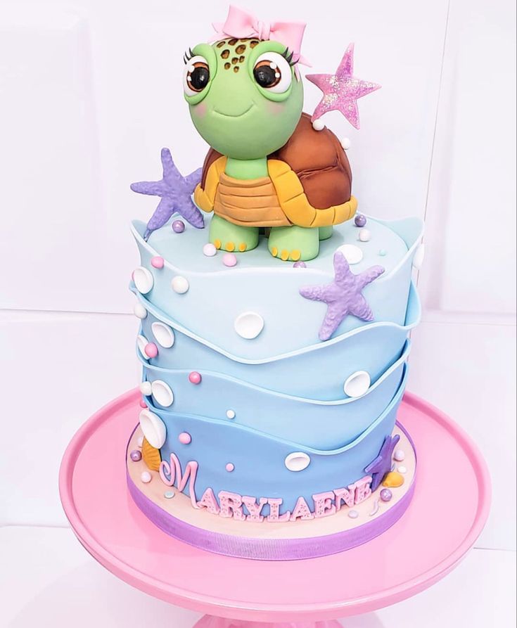 there is a cake that has a turtle on it and starfish around the edges