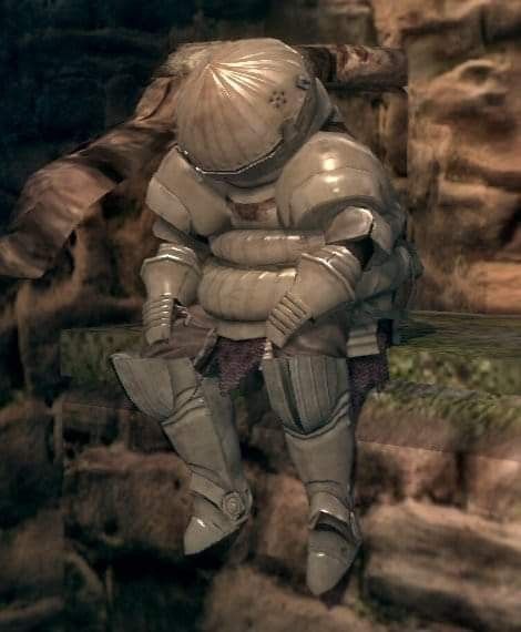 a man dressed in armor sitting on a ledge