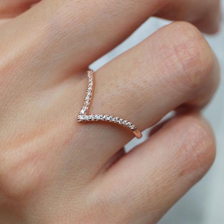 a woman's hand with a diamond ring on top of her finger and the band is