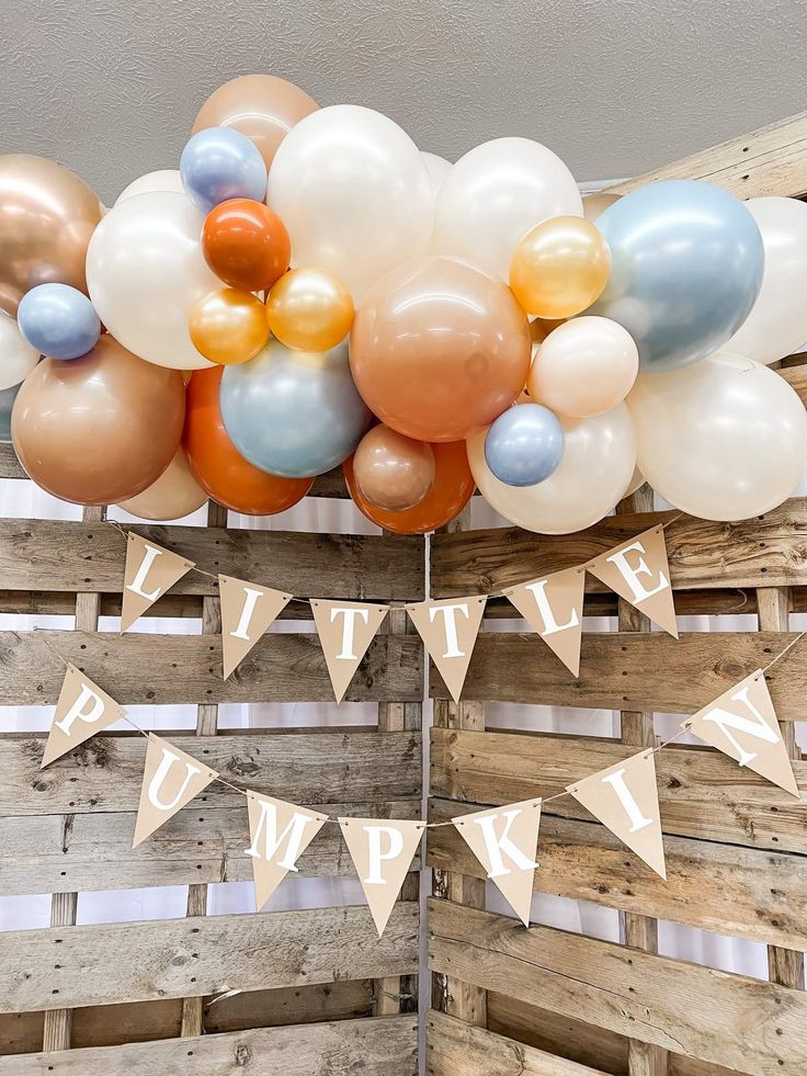 a bunch of balloons that are on top of some wooden pallets with bunting