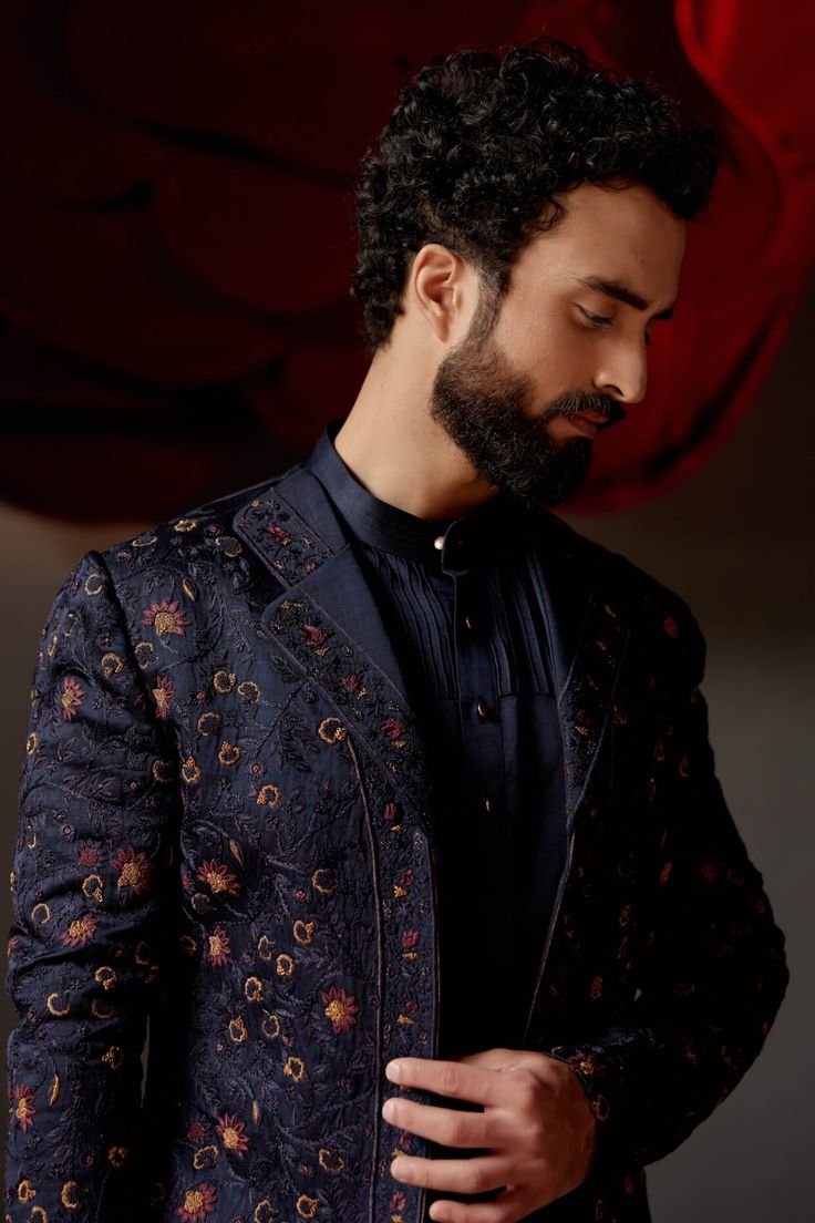 Editor's Note Featuring our midnight blue short jacket with double lapel detail. Hand-embroidered using zardozi technique with midnight and wine threads. Paired with a short length tone-on-tone kurta and tapered trousers. Fabric: Linen silk Color: Blue Components: Short jacket, kurta and trousers Occasion: Wedding guest Fit: Regular Note: Product colour may slightly vary due to photographic lighting sources Care: Dry clean only About the Designer After establishing himself as the leading couturi Designer Embroidered Nehru Jacket, Nehru Jacket With Intricate Embroidery For Party, Traditional Drape Nehru Jacket With Intricate Embroidery For Party, Elegant Festive Straight Kurta Outerwear, Semi-formal Blue Zari Work Sets, Blue Semi-formal Sets With Zari Work, Semi-formal Blue Sherwani With Zari Work, Party Wear Bandhgala With Traditional Drape For Festive Occasions, Blue Festive Bandhgala For Semi-formal Occasions