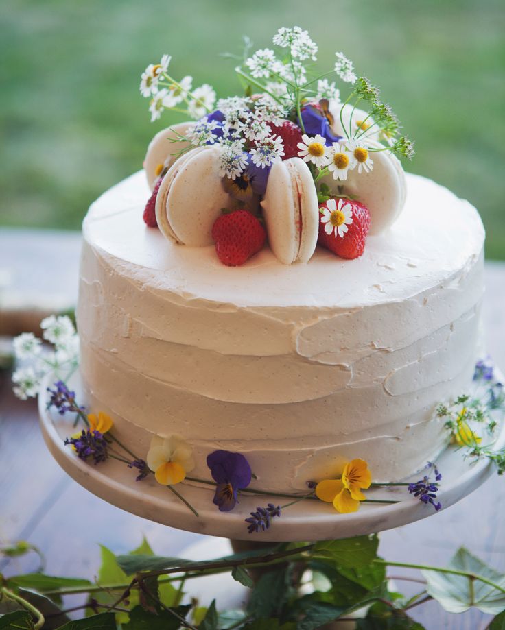 a white cake with strawberries and flowers on top