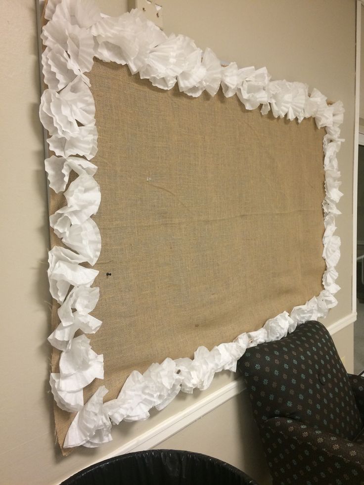 an old burlocked piece of cloth is hanging on the wall next to a chair