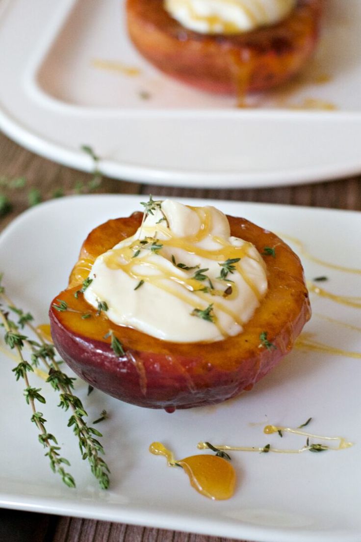 two white plates topped with food on top of a wooden table