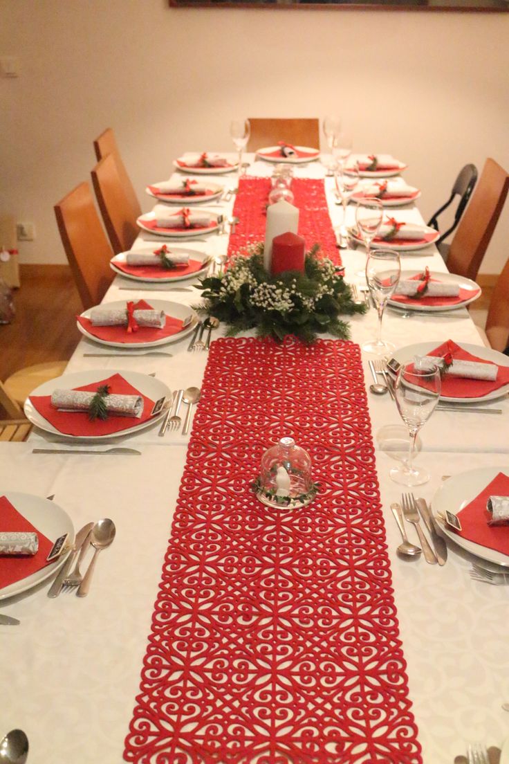 the table is set with red and white place settings