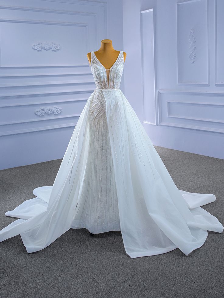 a wedding dress on display in a white room