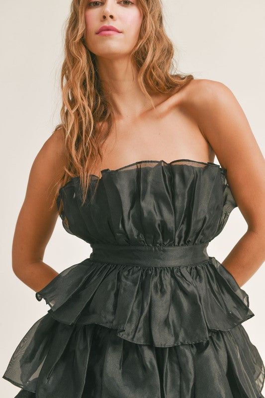 Mandy tiered ruffled organza tube mini dress is stunning and perfect for any occasion. A definite staple that needs to be in everyone's closet. Tiered Ruffle Dress For Night Out, Chic Organza Strapless Prom Dress, Chic Strapless Tiered Dress With Ruffle Hem, Elegant Mini Dress With Ruffles For Night Out, Chic Mini Tiered Party Dress, Tiered Ruffle Mini Dress For Night Out, Chic Tiered Dress With Layered Hem For Parties, Chic Mini Dress With Ruffled Straps For Prom, Elegant Party Mini Dress With Layered Hem