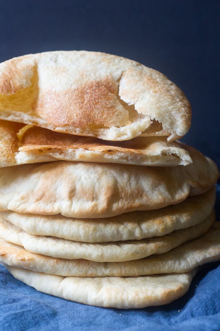 a stack of pita bread sitting on top of a blue cloth