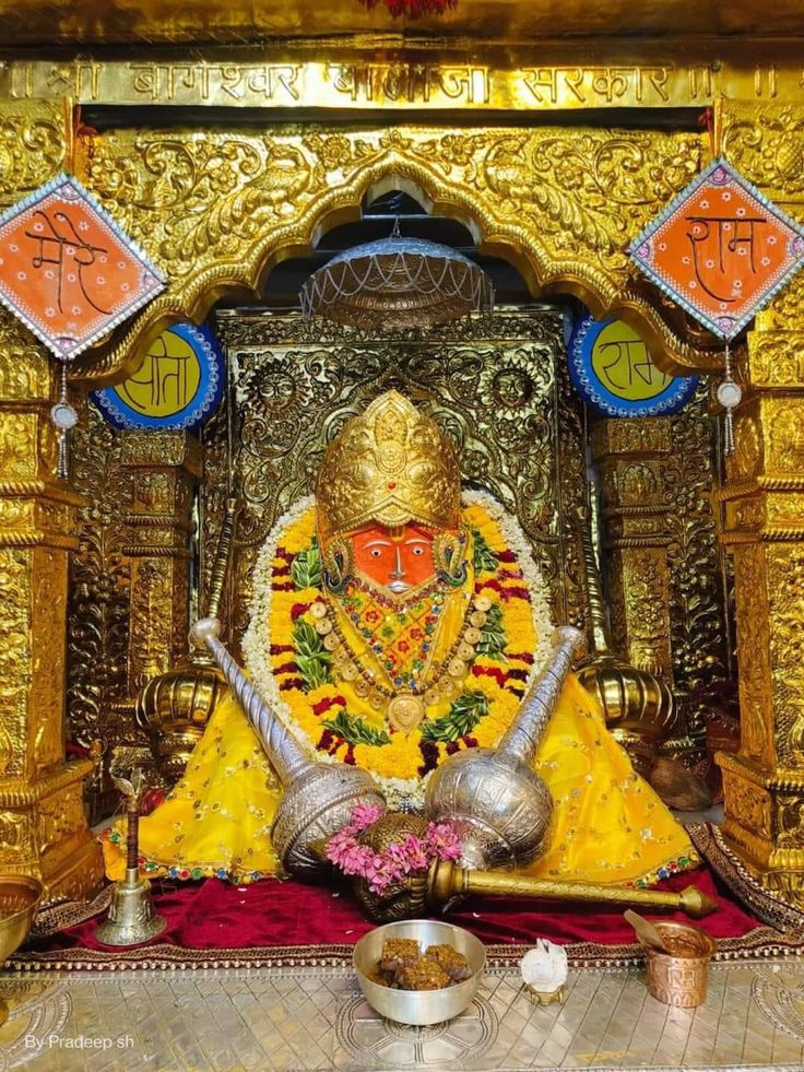 an idol is sitting in the middle of a room with gold and red decorations on it