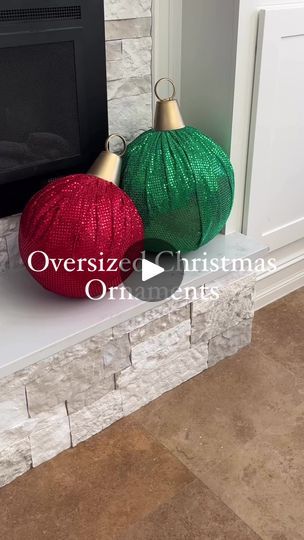 two christmas balls sitting on top of a fireplace