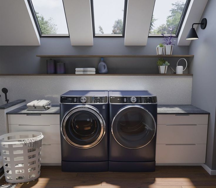 a washer and dryer in a room with skylights on the windows above