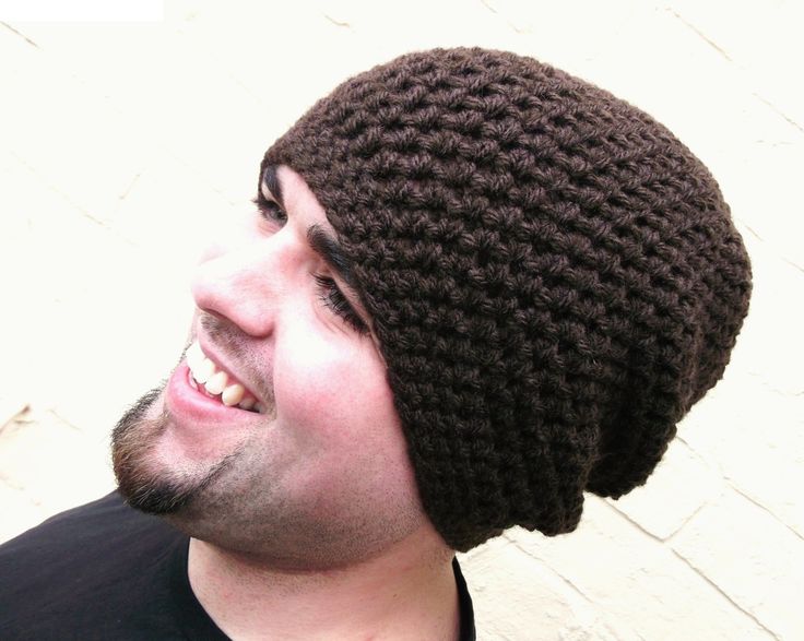 a close up of a person wearing a knitted hat with a smile on his face