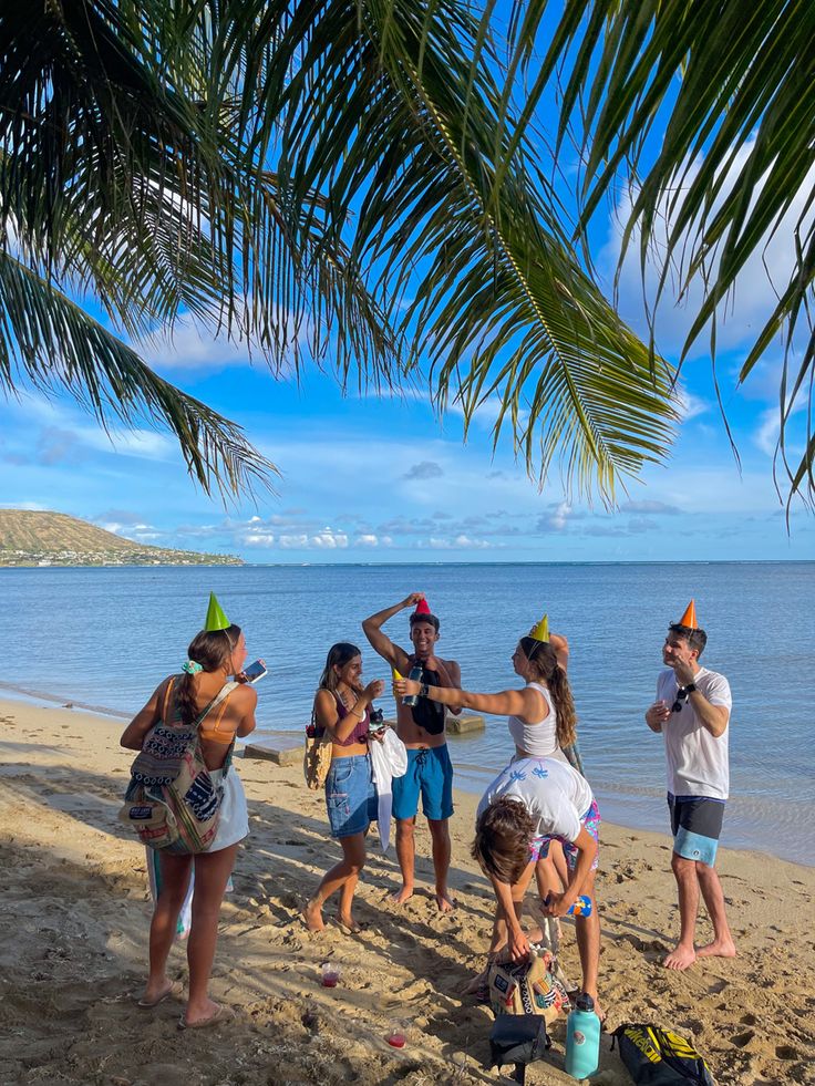 group of people standing on the beach near water