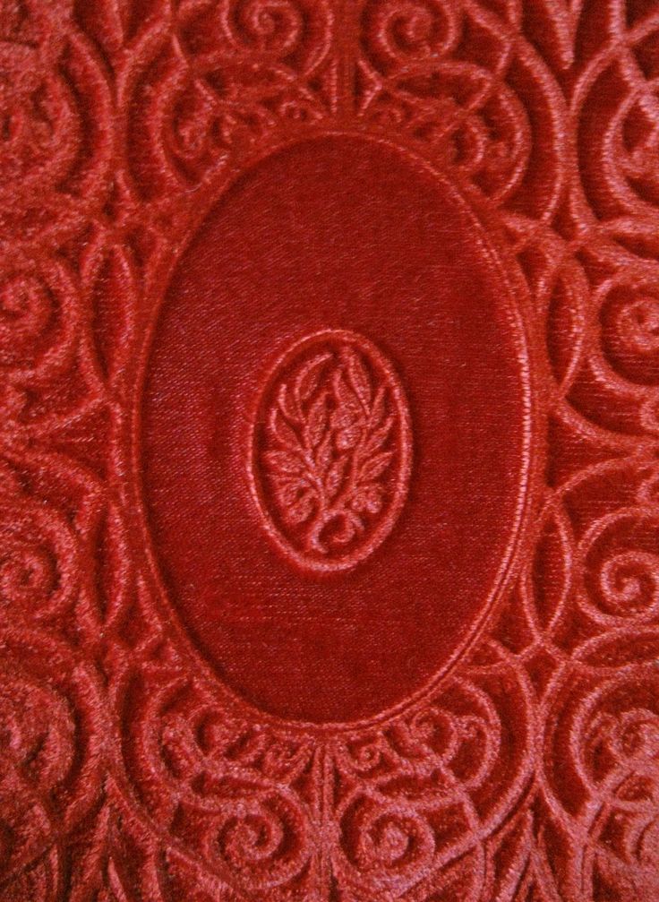 a close up view of a red cloth with an ornate design on the center and bottom