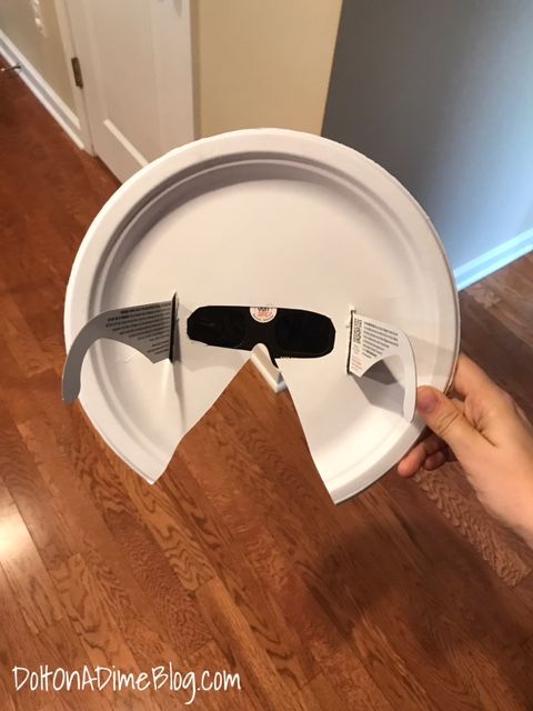 a paper plate with two knives cut out of it