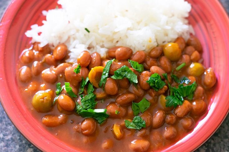 a red plate topped with beans and rice