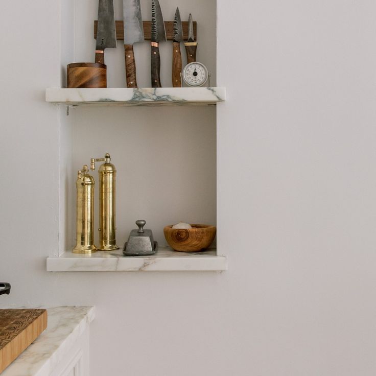 there are many different kitchen knives on the shelves above the sink and in the cabinet