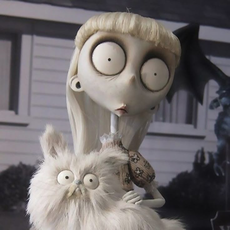 a creepy doll with an owl on her shoulder and a cat in the other hand