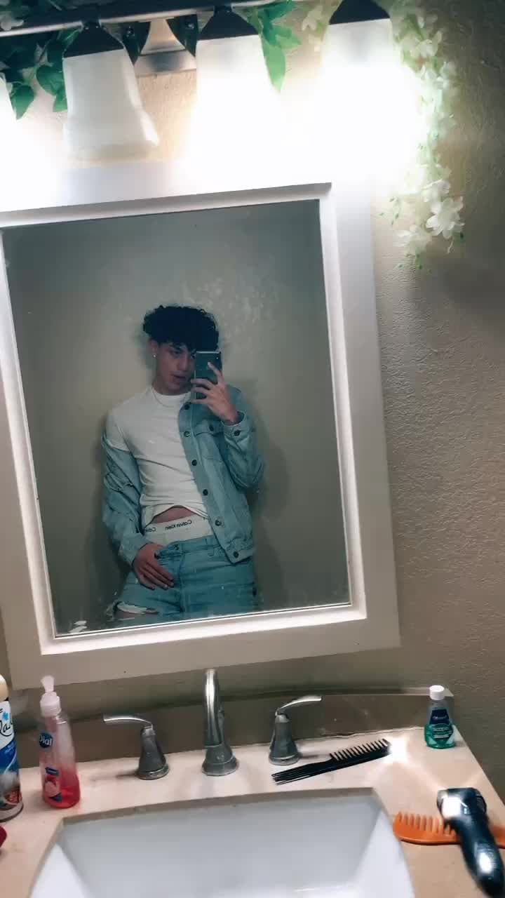 a man taking a selfie in front of a bathroom mirror