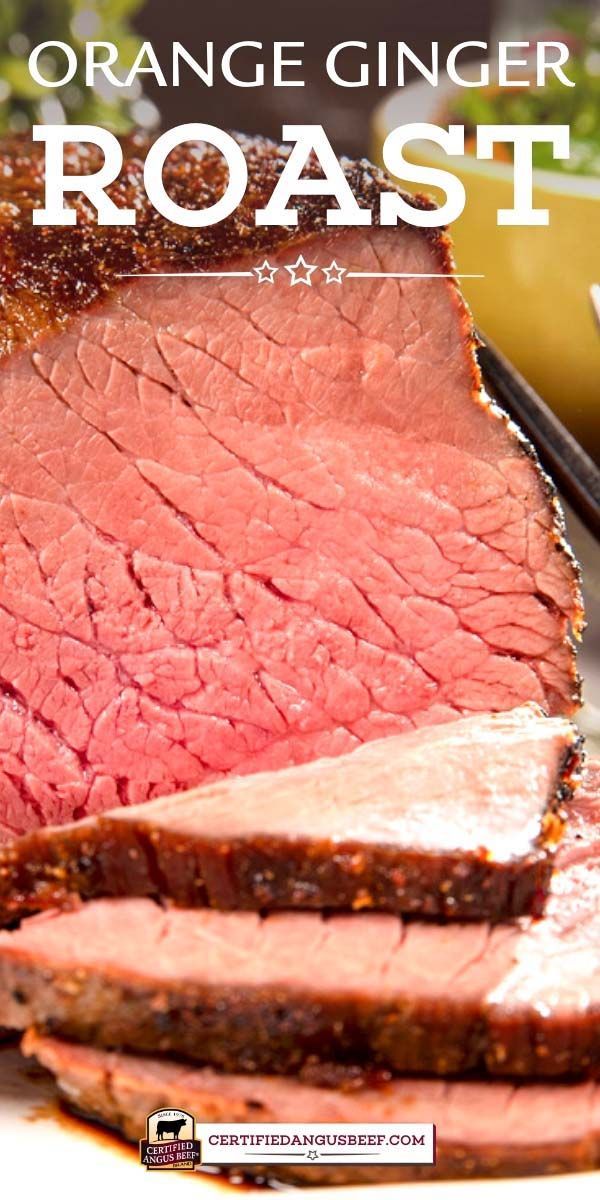 sliced roast beef on a plate with carrots in the background