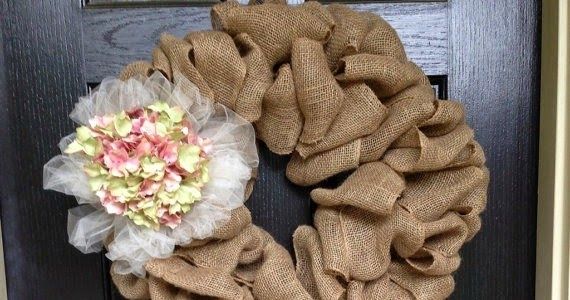 a burlock wreath with flowers on the front door