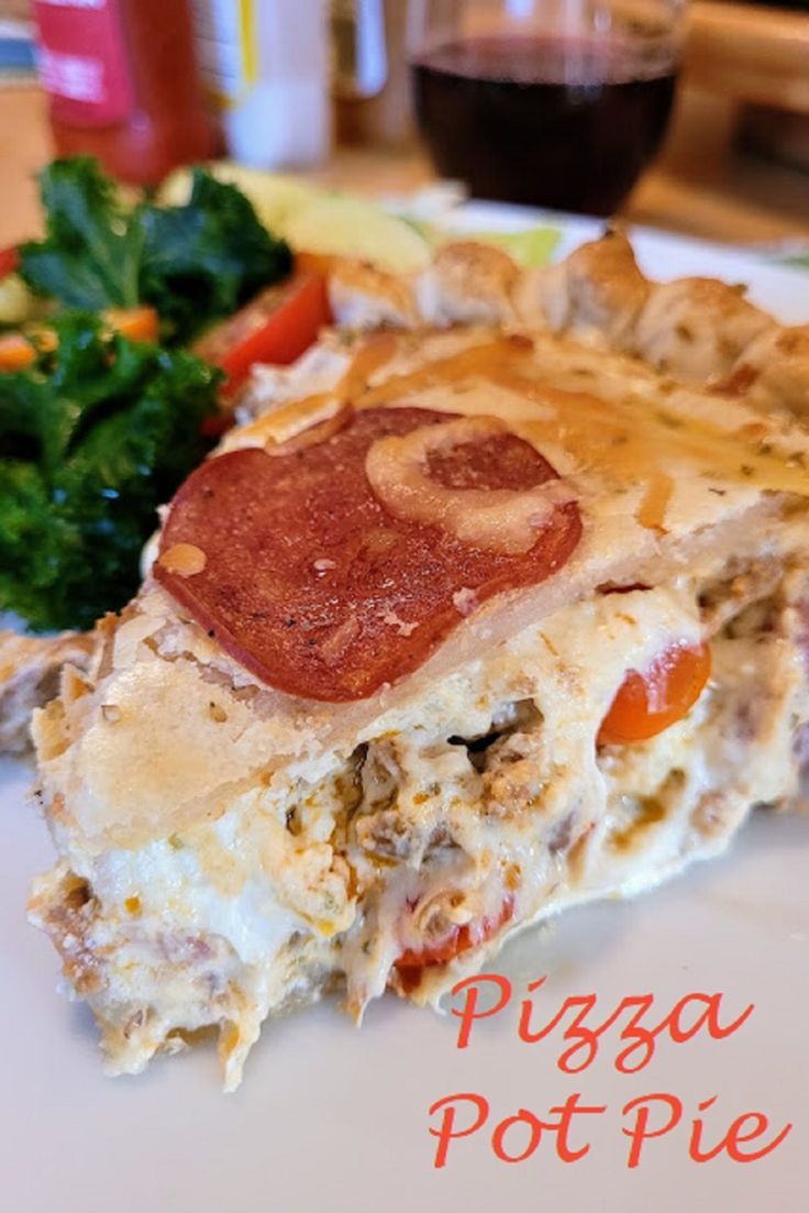 a piece of pizza sitting on top of a white plate next to a green leafy salad