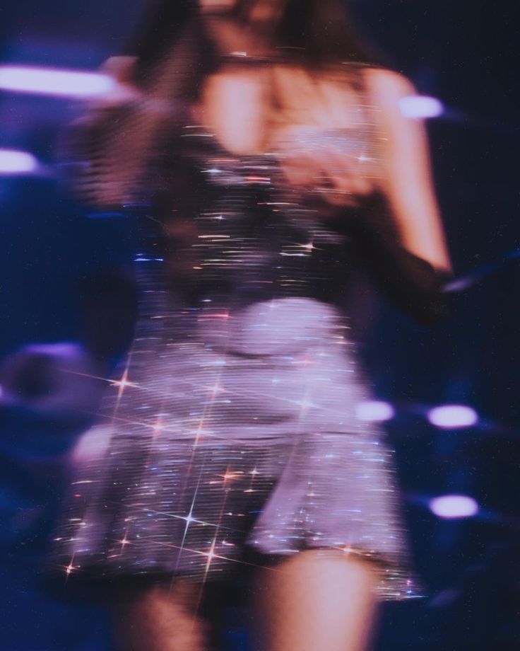 a blurry photo of a woman in a short skirt and heels on the runway