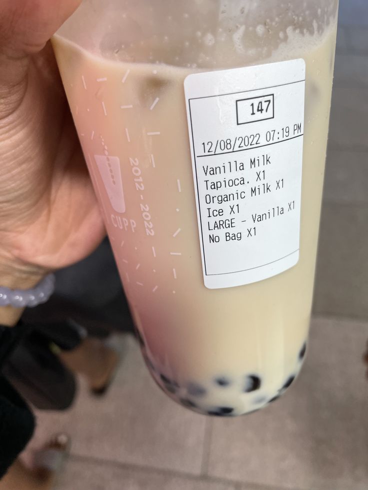 a person holding up a plastic cup filled with liquid