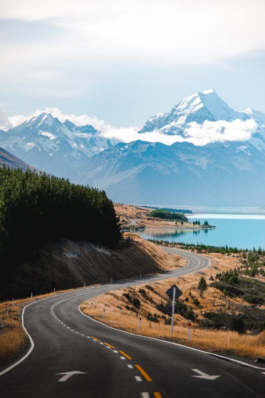 an empty road with mountains in the background