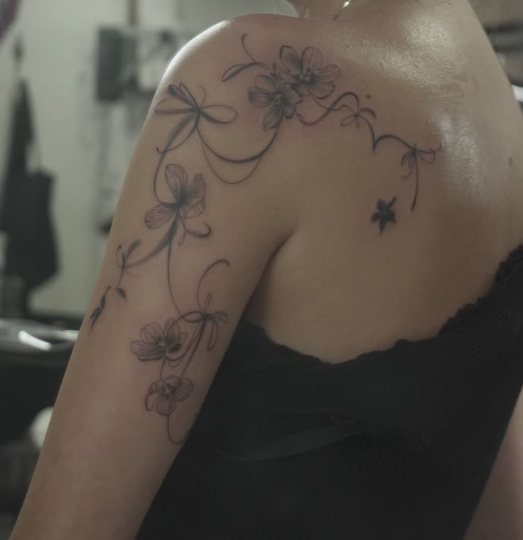 a woman with a flower tattoo on her shoulder