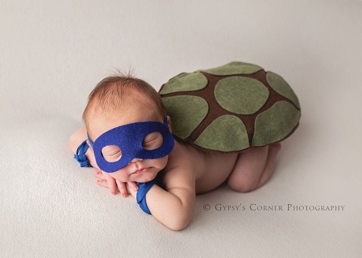 a baby is wearing a turtle costume while laying on its back with it's eyes closed